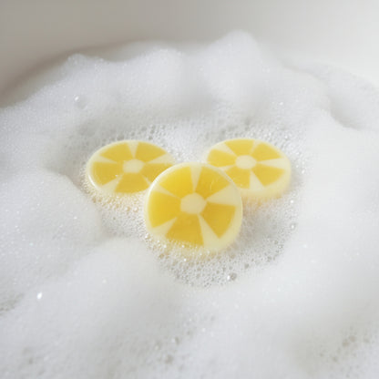 three lemon bar soaps in a bubble bath